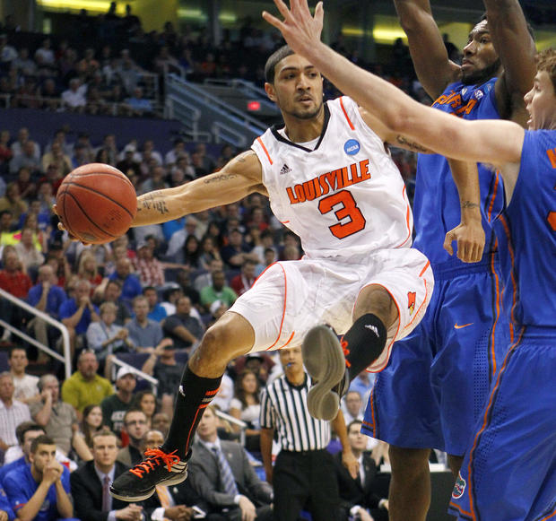 Peyton Siva moves the ball against Florida defenders  