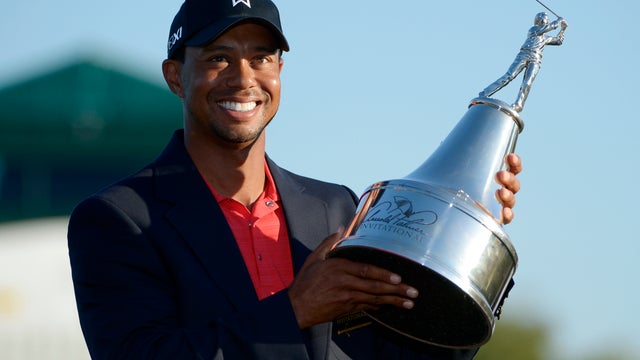 Tiger Woods hoists the championship trophy after winning the Arnold Palmer Invitational  