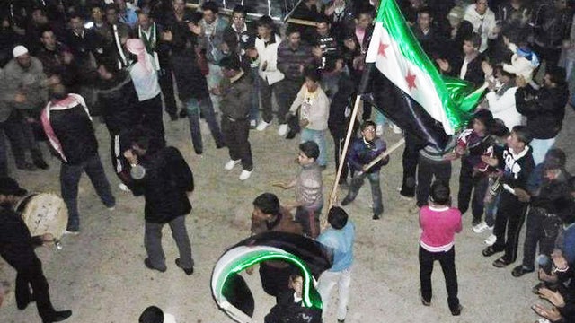 In this March 27, 2012 citizen journalism image provided by the Local Coordination Committees in Syria, protesters wave Syrian revolutionary flags during a demonstration in Daraa, Syria. 