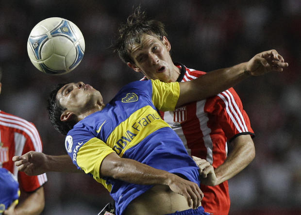 Boca Juniors' Cristian Chavez, left, and Raul Iberbia of Estudiantes de La Plata battle for the ball  