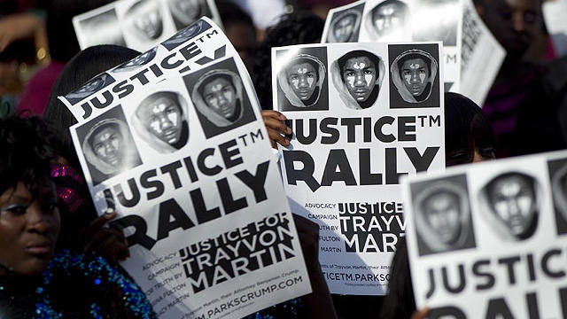 Members of the audience hold signs of support as thousands gathered in downtown Miami, Sunday, April 1, 2012, demanding justice for Trayvon Martin during a rally that featured national civil rights leaders. 