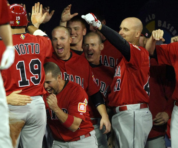 Joey Votto of Canada is congratulated by teammates  