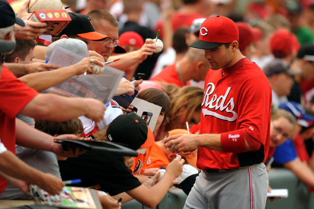 Joey Votto signs autographs before a baseball game 