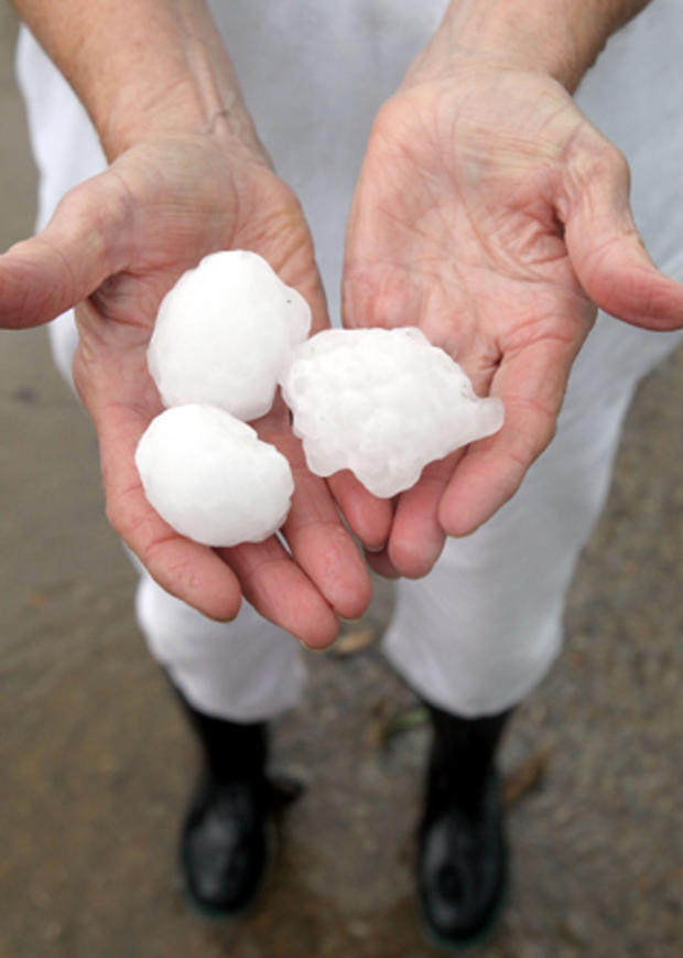 Melba Baker holds some of the golf ball plus size hail that fell at her home 
