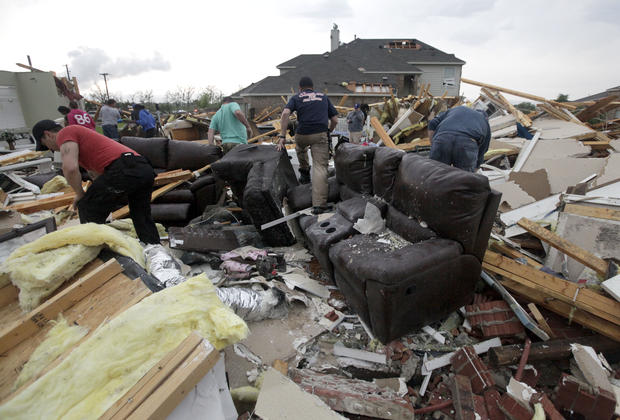 Friends and neighbors help a home owner recover personal items after a tornado nearly the entire structure 