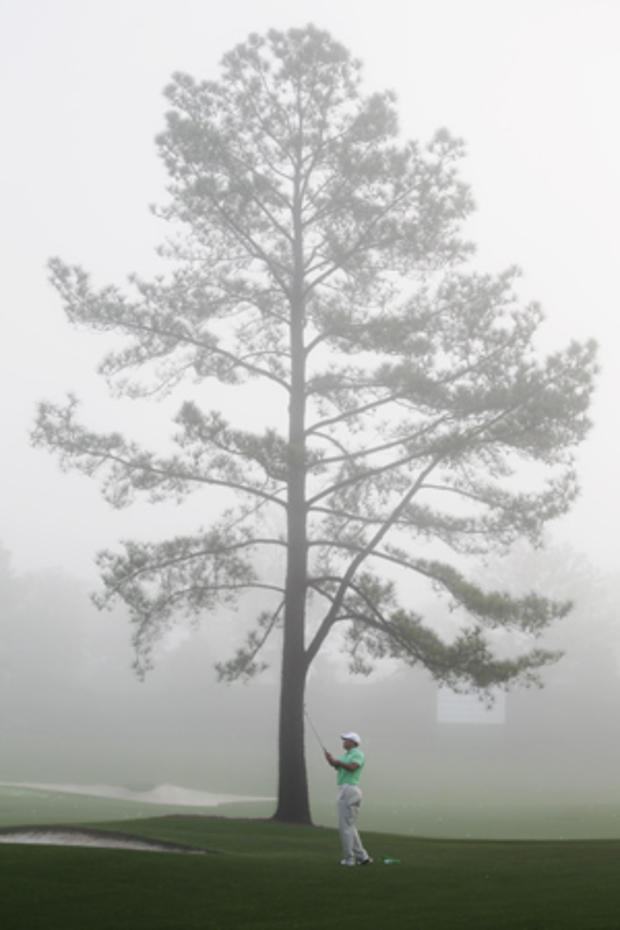 Tiger Woods hits on a fog covered driving range 