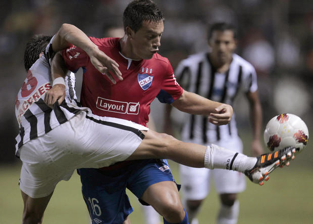 Victor Caceres and Nacional's Matias Abero battle for the ball 