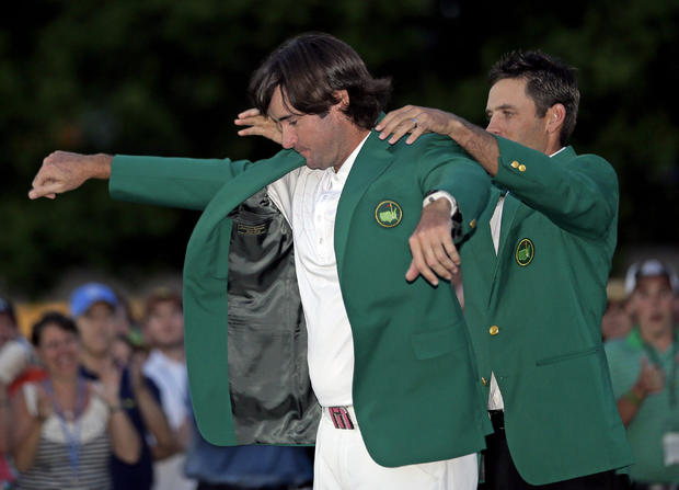 Charl Schwartzel, right, of South Africa, helps Bubba Watson put on the green jacket after winning the Masters golf tournament 