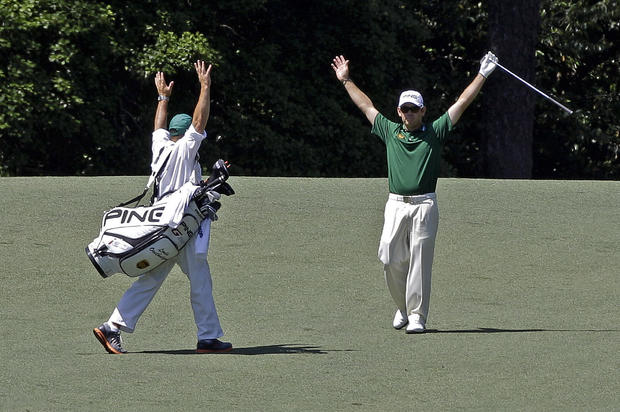 Louis Oosthuizen, of South Africa, and his caddie Wynand Stander react after Oosthuizen's double eagle two 