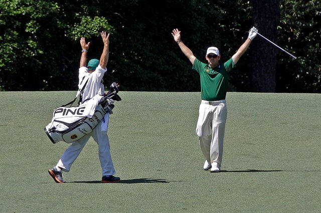 Louis Oosthuizen, of South Africa, and his caddie Wynand Stander react after Oosthuizen's double eagle two 