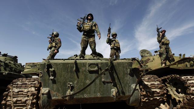 In this March 22, 2011, file photo, Afghan National Special Force soldiers stand on tanks which were destroyed in Soviet occupation and civil war, during a training session at Camp Morehead on the outskirts of Kabul, Afghanistan.  