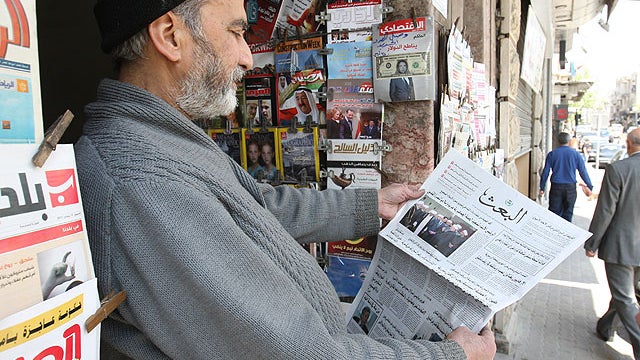 A Syrian man reads the local 'Baath' newspaper in Damascus on April 12, 2012, as a UN-backed ceasefire went into effect.  