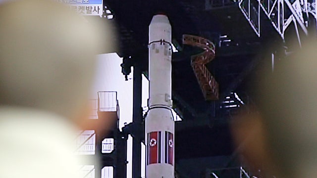 South Korean Buddhist monks watch a TV news report about North Korea's long-range rocket at a Seoul train station in Seoul, South Korea, April 13, 2012. 