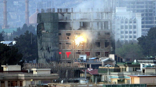 Gunfire and smoke are seen coming out of a building occupied by militants during a battle with Afghan-led forces in Kabul, Afghanistan, April 16, 2012. 