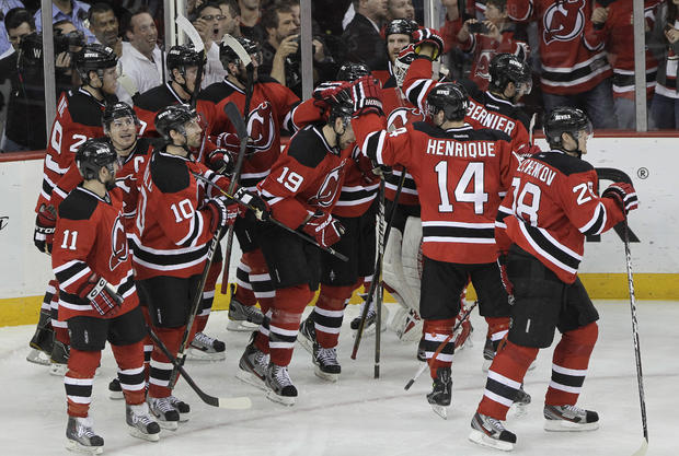 Travis Zajac is congratulated by teammates after his overtime goal 