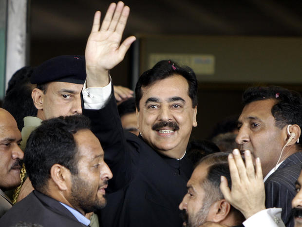 Pakistani Prime Minister Yousuf Raza Gilani, center, waves upon his arrival at the Supreme Court for a hearing in Islamabad, Pakistan, April 26, 2012. 