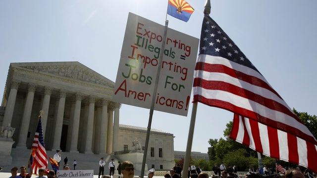 Supporters of Arizona's "show me your papers" immigration law rally in front of the Supreme Court in Washington, Wednesday, April 25, 2012, where the court held a hearing.  