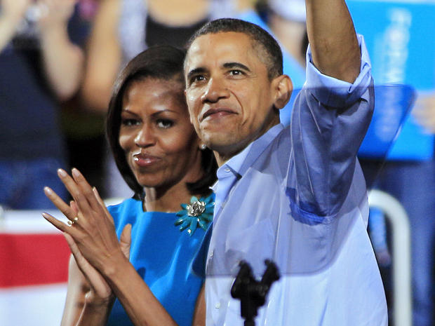 President Barack Obama waves with first lady Michelle Obama after a campaign rally 