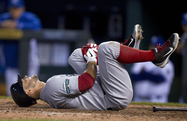 Cody Ross holds his leg after fouling off a pitch 