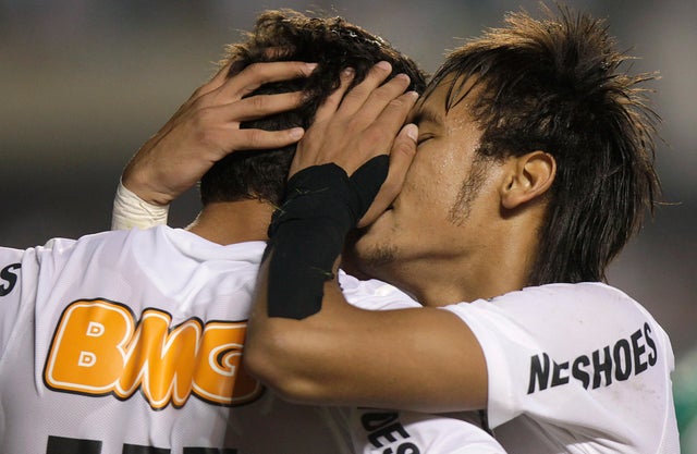 Santos' Neymar, right, embraces teammate Paulo Henrique Ganso 