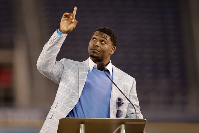 LaDainian Tomlinson points upward during a public memorial service 