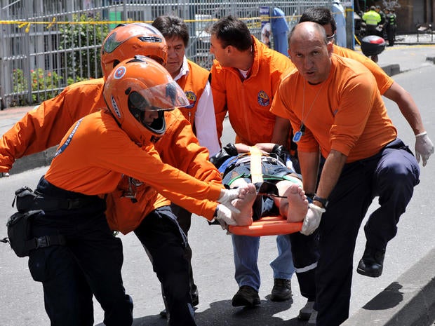 Emergency personnel assist an injured person after an explosion ripped through a crowded area of Bogota, Colombia, May 15, 2012. 