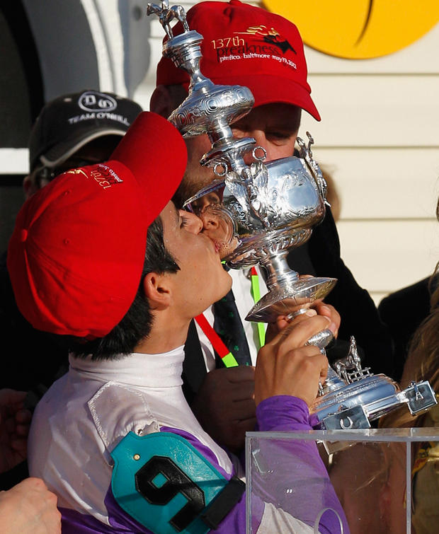 Jockey Mario Gutierrez kisses the trophy in the winners circle 
