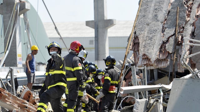 Firefighters search the debris of a collapsed factory in Mirandola, northern Italy 