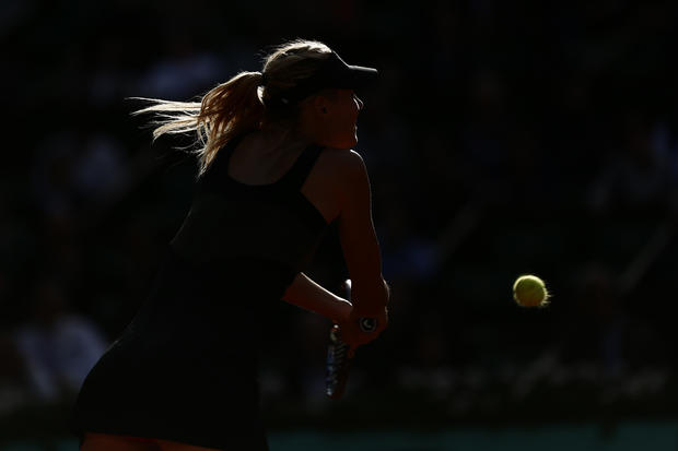 Maria Sharapova is silhouetted by a ray of sunlight  
