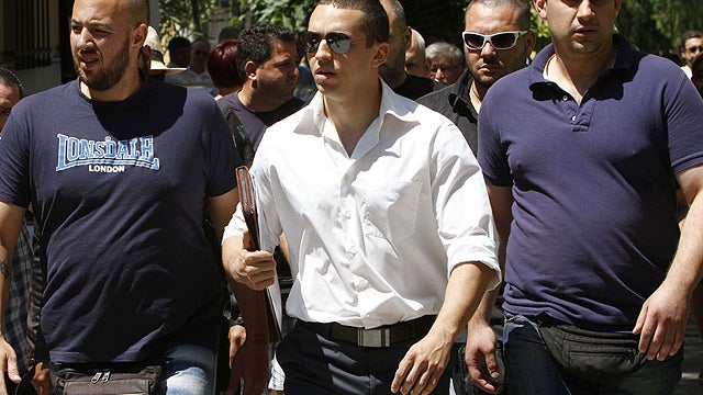The spokesman of Greece's extreme-right Golden Dawn party Ilias Kasidiaris, center, escorted by party members arrives at the prosecutor's office in Athens, June, 11, 2012.  