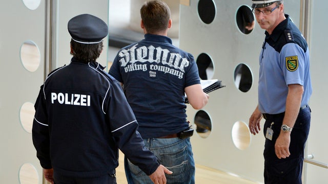 Poice accompany lawmakers of the right-wing NPD out of the federal parliament of Saxony state in Dresden, Wednesday June 13, 2012. The president of Saxony's state parliament has expelled eight far-right lawmakers from the assembly for wearing clothes favo 