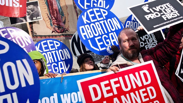 An anti-abortion-rights activist stands in front of pro-abortion-rights activists with the National Organization for Women at a vigil outside the U.S. Supreme Court Jan. 23, 2012, in Washington. 
