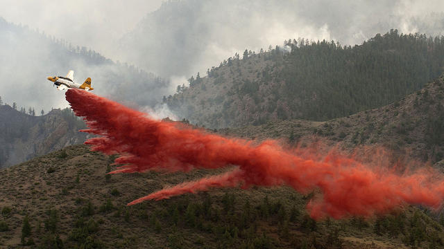 Aircraft drops a load of fire retardant slurry above the High Park wildfire 