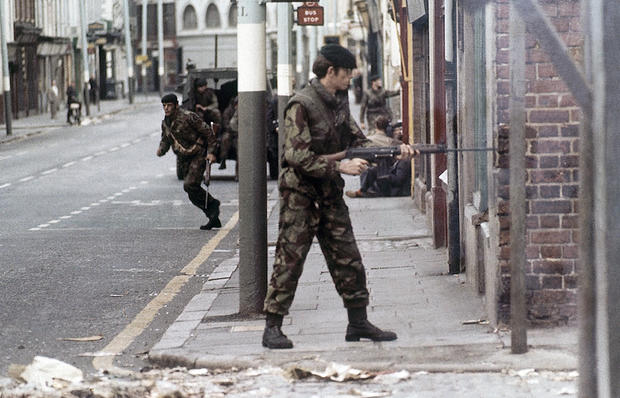 Armed British troops patrol in the almost deserted streets of Ulster 