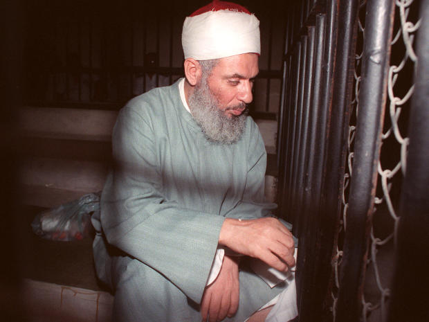 Blind sheik Omar Abdel-Rahman sits and prays inside an iron cage at the opening of court session in Cairo Aug. 6, 1989. 