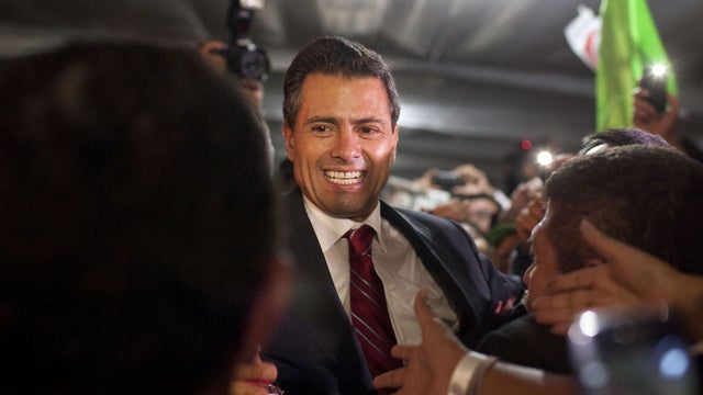 Enrique Pena Nieto, presidential candidate for the Revolutionary Institutional Party (PRI), greets supporters at his party's headquarters in Mexico City, early Monday, July 2, 2012.  