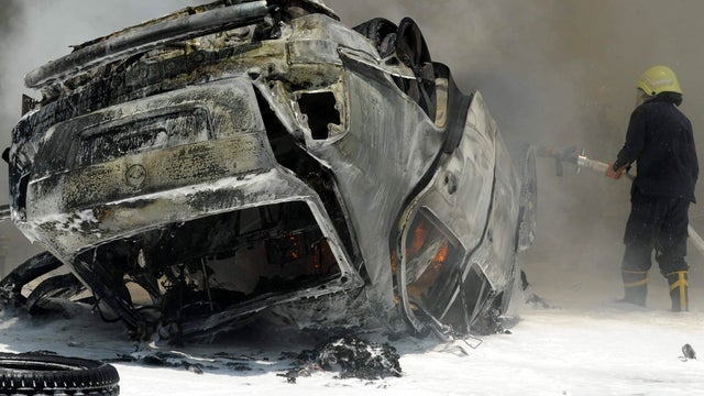 A Syrian fireman tries to extinguish fires at the scene of two huge bomb explosions outside the Palace of Justice in central Damascus, Syria, June 28, 2012. 