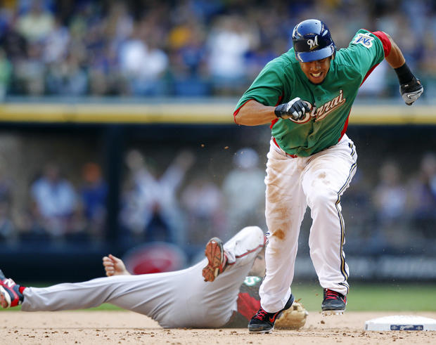 Aaron Hill lays on the ground as Carlos Gomez heads to third base  