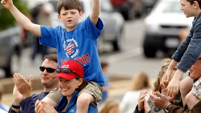 Children and their parents cheer and applaud after the space shuttle Discovery, teathered to the back of a modified 747 jumbo jet, flew over the Smithsonian National Air and Space Museum Steven F. Udvar-Hazy Center April 17, 2012, in Chantilly, Va. 