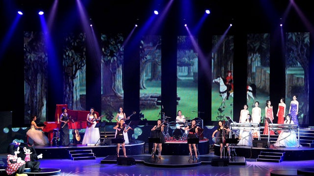 Mickey and Minnie have a chat on left as North Korea's new Moranbong band performs in Pyongyang, North Korea, Friday, July 6, 2012. 