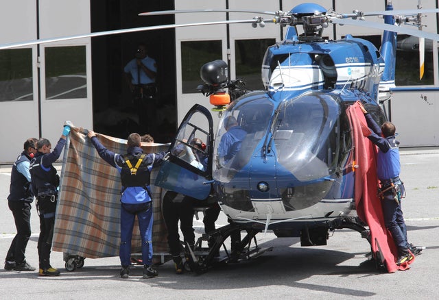 Gendarmes use blankets to hide victims of an avalanche at Chamonix rescue base, French Alps, Thursday, July, 12, 2012. An avalanche in the French Alps swept six European climbers to their deaths on a slope leading to Mont Blanc, and left at least nine others injured and several climbers unaccounted for, authorities said. Two climbers were rescued and emergency crews are searching for the missing. A group of 28 climbers from Switzerland, Germany, Spain, France, Denmark and Serbia are believed to be in the expedition caught in the avalanche that was about 4,000 meters (13,1000 feet) high on the north face of Mont Maudit, part of the Mont Blanc range. 