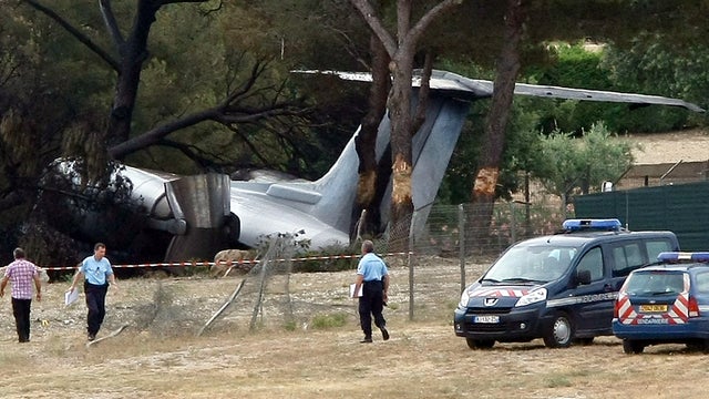 Police officers walk near a plane that crashed on landing at Castellet International Airport near Toulon, France, July 13, 2012. 