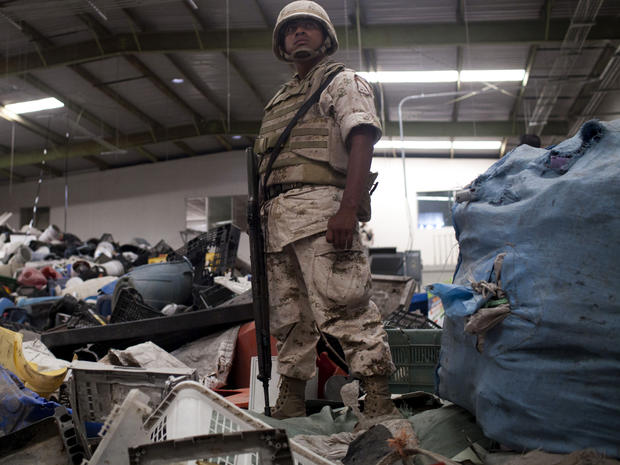 A Mexican army soldier stands inside a warehouse used for recycling assorted materials where an incomplete cross-border illegal tunnel was found underneath a bathroom sink by the Mexican army in Tijuana, Mexico, July 12, 2012. 