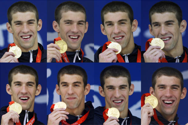 Michael Phelps holding each of his eight gold medals 