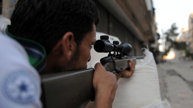 A fighter from the Syrian opposition aims during clashes with forces loyal to President Bashar Assad in the center of Syria's restive northern city of Aleppo, Syria, July 25, 2012. 