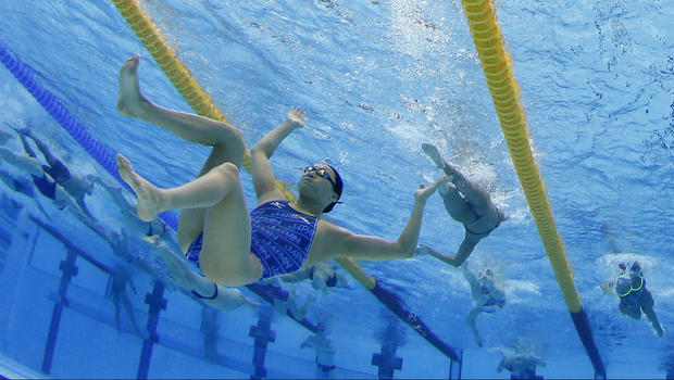 A swimmer floats in the pool during a practice 