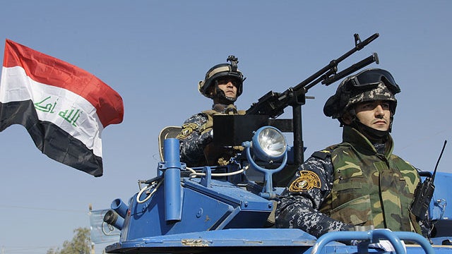 In this Nov. 22, 2011 file photo, the Iraqi flag waves while federal police parade in Baghdad.  