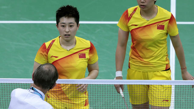 An unidentified official talks to world doubles champions Yu Yang, left, and Wang Xiaoli 