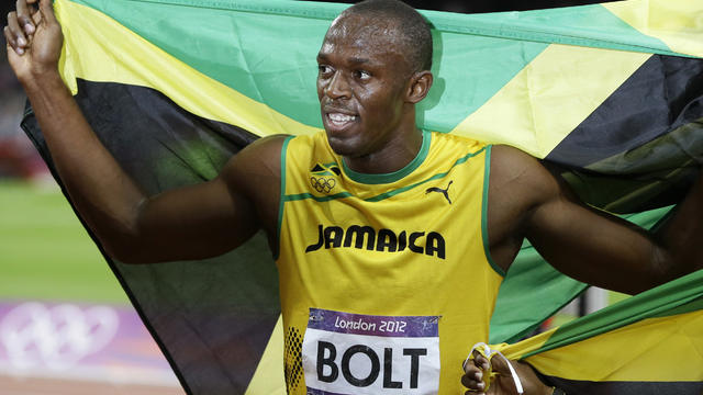 Jamaica's Usain Bolt holds his national flag after winning men's 100-meter final Sunday 