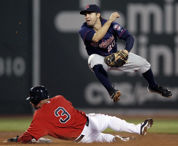 Brian Dozier completes a double play while avoiding sliding Mike Aviles  